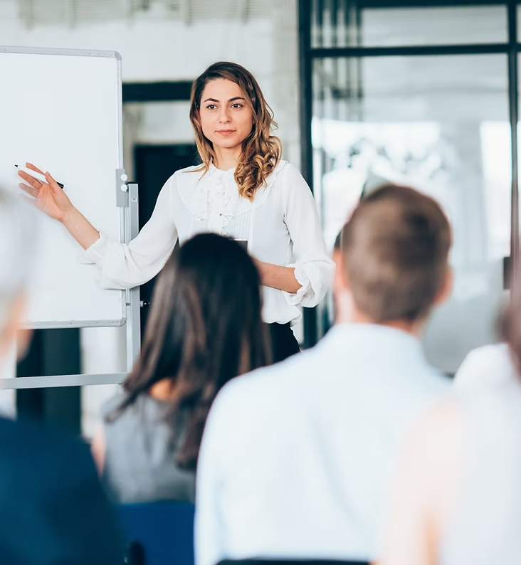 Professional woman presenting ideas to engaged audience.